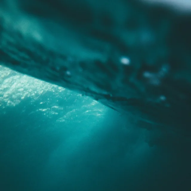 La superficie del mar vista desde debajo del agua, desenfocada en tonos turquesa